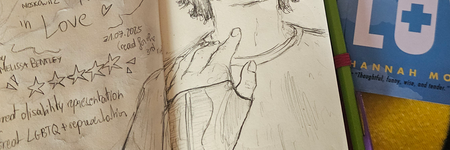 photo d'un carnet de croquis ouvert à côté d'un livre